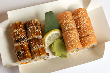 Sushi rolls  in a white eco paper lunch box takeaway. Japanese dish. 