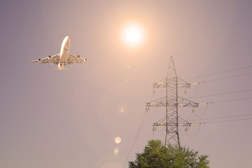 Airliner over a high-voltage post. Sunset.