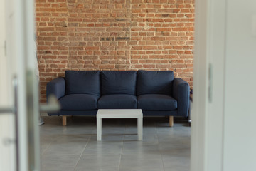 Opened white wooden door to modern living room interior. Modern room interior background.
