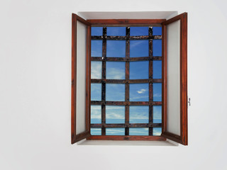 Barred window, no escape. Mental health or captive trap concept. Old irons bars but sea and sky visible.