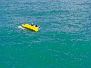Aerial view of strong young active men capsizing with their kayak on the clear blue  turquoise water of the ocean. Active vacation. Praia do Forte, Brazil. 