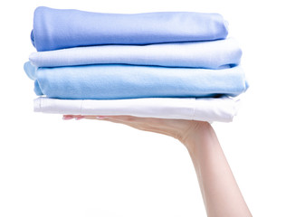 Stack blue folded clothing in hand on white background isolation