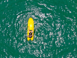 Aerial view of strong young active men kayaking on the clear blue  turquoise water of the ocean. Active vacation. Praia do Forte, Brazil