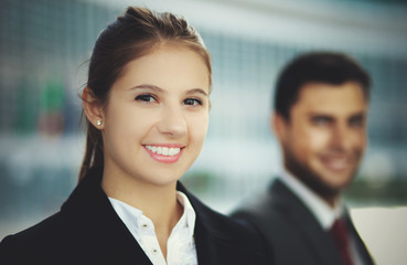 Two business people smiling in an urban setting