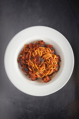 Spaghetti with beef sauces dish on wood plate on iron table