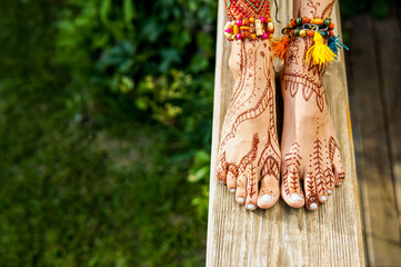 Beautiful legs with accessories and mehendi painting outdoors