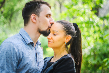 Fototapeta premium Outdoor portrait of a couple in love. Man kissing his wife