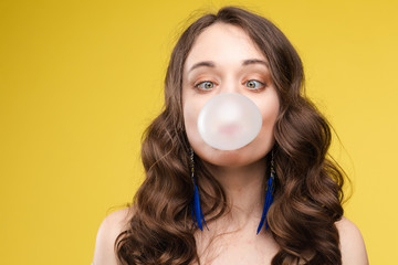 Charming young girl blowing bubble from chewing gum