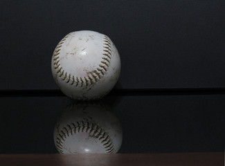 A horizontal photo of a baseball with a black background.