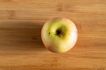 One beautiful red yellow Apple on a wooden background