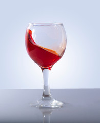 Blue or red splash in wine glass on white