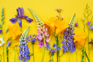 Bright composition of summer flowers on the yellow background © alinakho