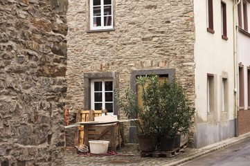 Alley of a stone house with tools and wooden objects (Germany, Europe)