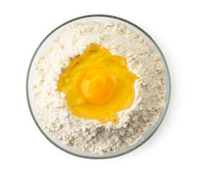 Broken egg in a plate of flour on a white. The form of the top.