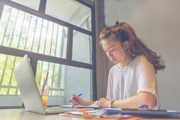 Young millennial working with laptop and paper document