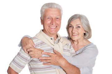 Portrait of happy senior couple hugging on white background