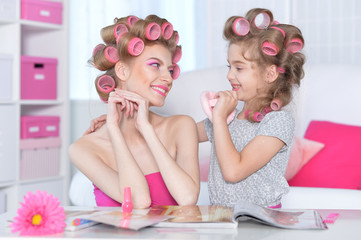 portrait of happy  Mother and little daughter with hair curlers