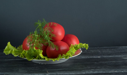 lettuce, tomatoes and dill on a white plate