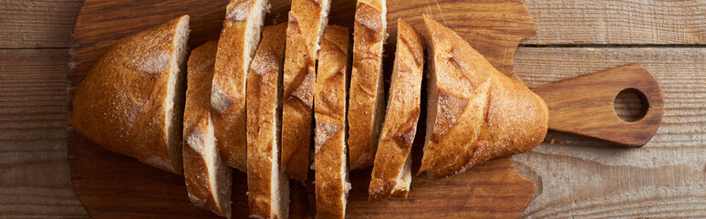 top view of slices of white bread on wooden chopping board, panoramic shot