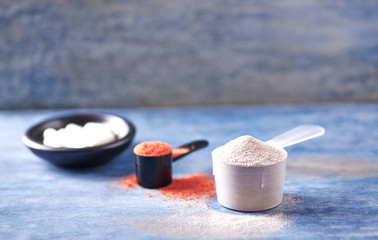 Scoop of Whey Protein, Creatine Powder and Taurine capsules. Sport nutrition. Rustic wooden background. Close up. Copy space