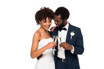 happy african american bride and bridegroom clinking champagne glasses isolated on white