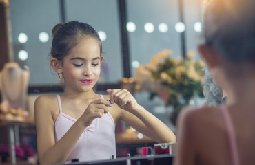 Beautiful girl, a ballet dancer Looking at the mirror and lipstick makeup behind the stage before...