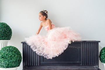 Cute little girl dreaming lying  on piano put pink tutu skirts dancing like ballerinas  in class...