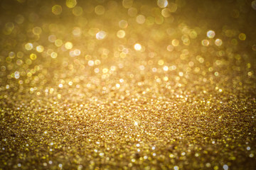 gold Sparkling Lights Festive background with texture. Abstract Christmas twinkled bright bokeh defocused and Falling stars. Winter Card or invitation