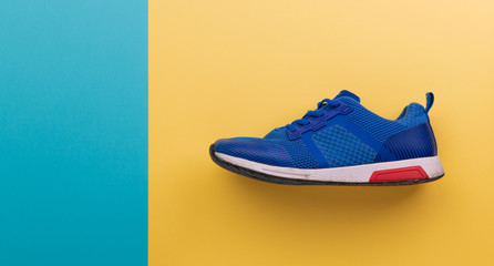 A studio shot of running shoe on yellow background. Flat lay.