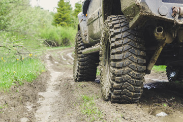 Fototapeta premium Dirty cars and wheels in the mountains. Swamp on the tires. Trips offroad across Ukraine. View of the Carpathian Mountains.
