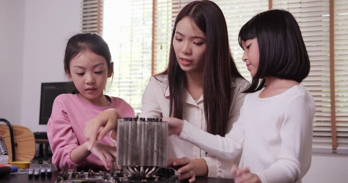 Teacher and her student work on a programable computer heard wear at school science class project. Technology and Education concept.