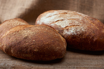 close up view of tasty fresh bread loaves on wooden table