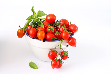 Fresh cherry tomatoes and basil on white background