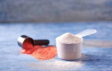 Scoop of Whey Protein and Creatine Powder. Sport nutrition. Rustic wooden background. Close up. Copy space