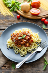 Spaghetti on black plate on wooden background. top view