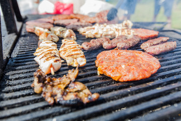 Grilled burger and chicken meat on barbecue at picnic