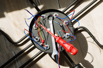 Obraz premium Chandelier with wires and tools on the floor, preparation to installation
