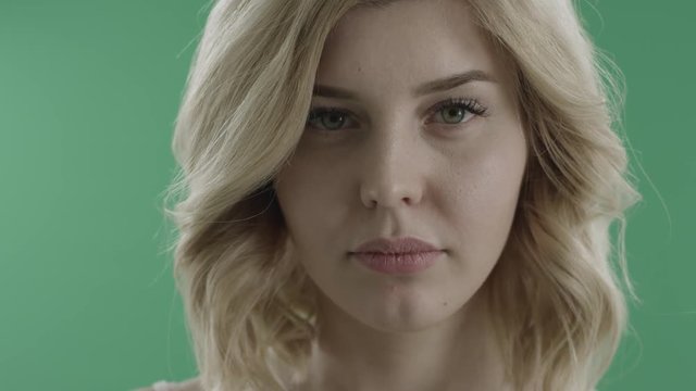 Shy hot young woman teases you against green screen