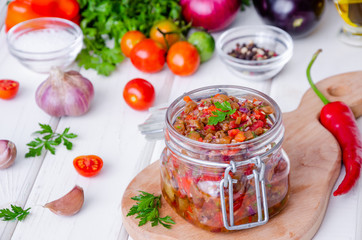 Eggplant caviar with tomatoes and roasted bell pepper in a glass jar