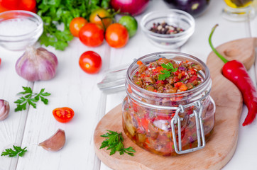 Eggplant caviar with tomatoes and roasted bell pepper in a glass jar