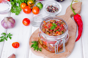 Eggplant caviar with tomatoes and roasted bell pepper in a glass jar