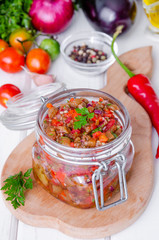 Eggplant caviar with tomatoes and roasted bell pepper in a glass jar