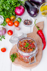 Eggplant caviar with tomatoes and roasted bell pepper in a glass jar