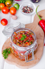 Eggplant caviar with tomatoes and roasted bell pepper in a glass jar