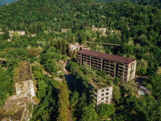 Fototapeta na wymiar Ruined lost overgrown mining ghost town Akarmara, consequences of war in Abkhazia, aerial view from drone