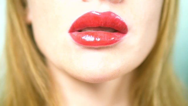 Close-up. sexy lips of a beautiful woman with beautiful red makeup, licks her lips