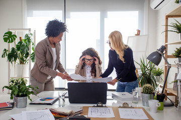 Three multiethnic woman at the office try to solve problems at work