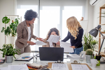 Three multiethnic woman at the office try to solve problems at work