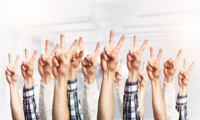 Row of man hands showing victory gesture