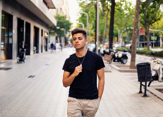 Young fashionable handsome man on the street of modern city. He looks happy